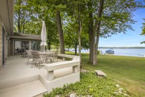 Image for Big Platte Lake waterfront home on Birch Drive shows part of the deck overlooking the yard and lake.